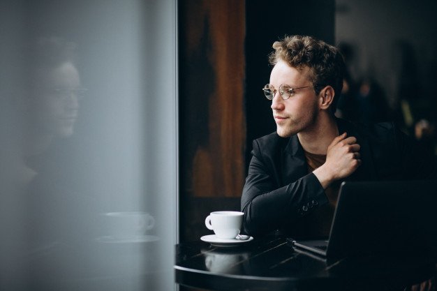 man drinking coffee by the window